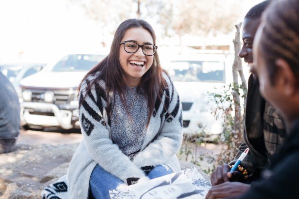 Young person smiling with two friends