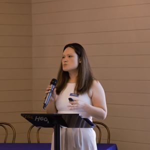 Woman addressing audience with microphone.