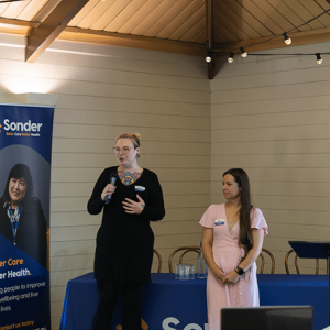 Person addressing audience with microphone.